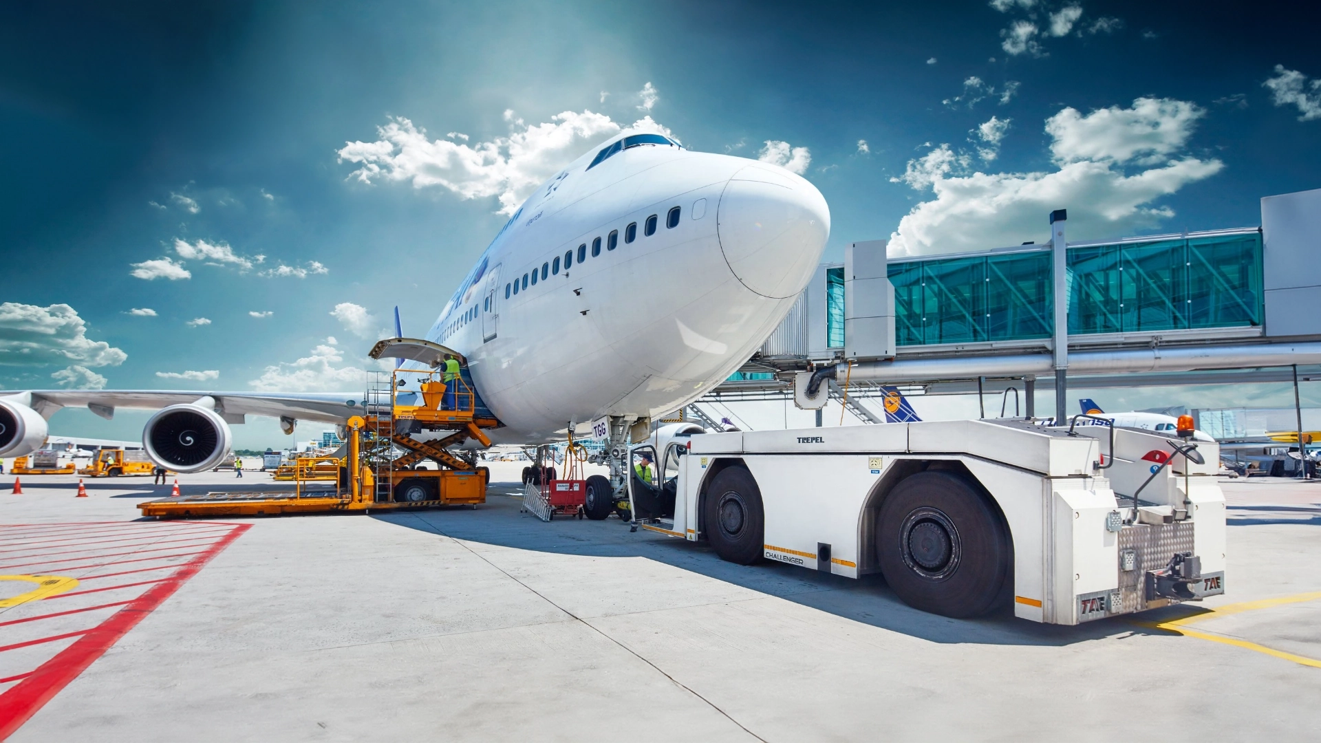 TREPEL aircraft tow tractor in front of Boeing at airport gate