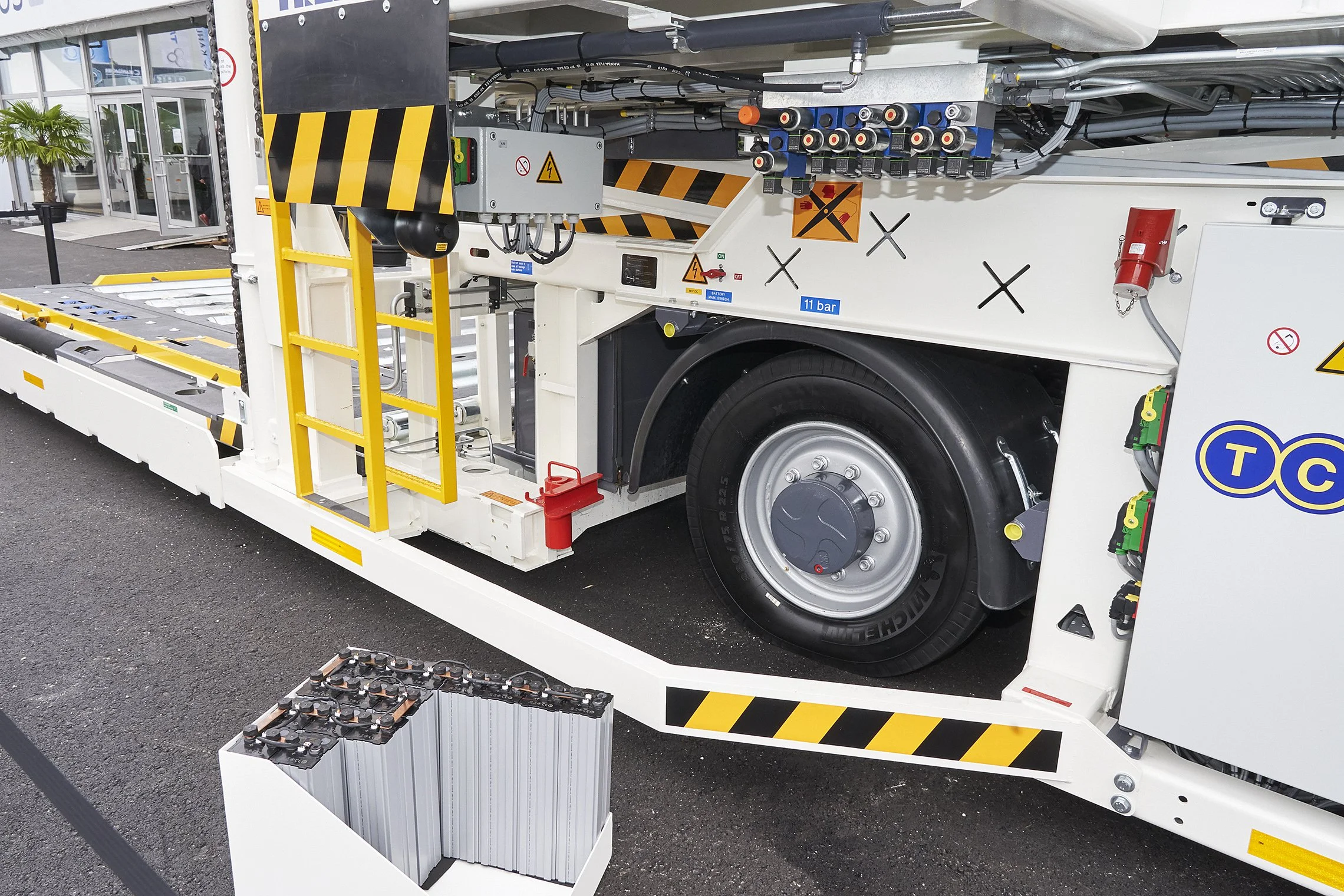 Close-up of wheel, control panel, and battery pack of a TREPEL high loader on outdoor display