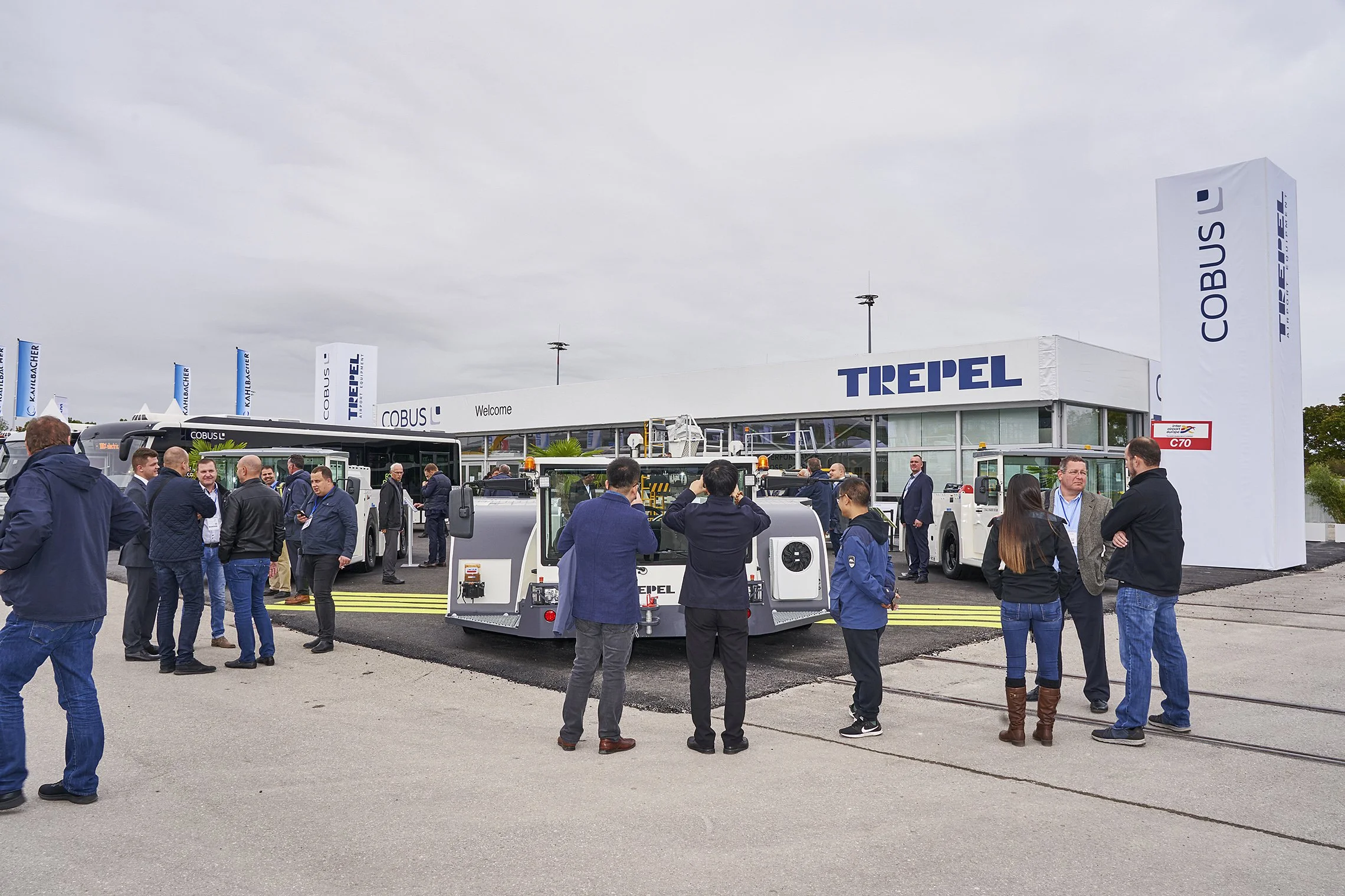 Visitors gathered around TREPEL aircraft tractors at the outdoor booth with TREPEL branding