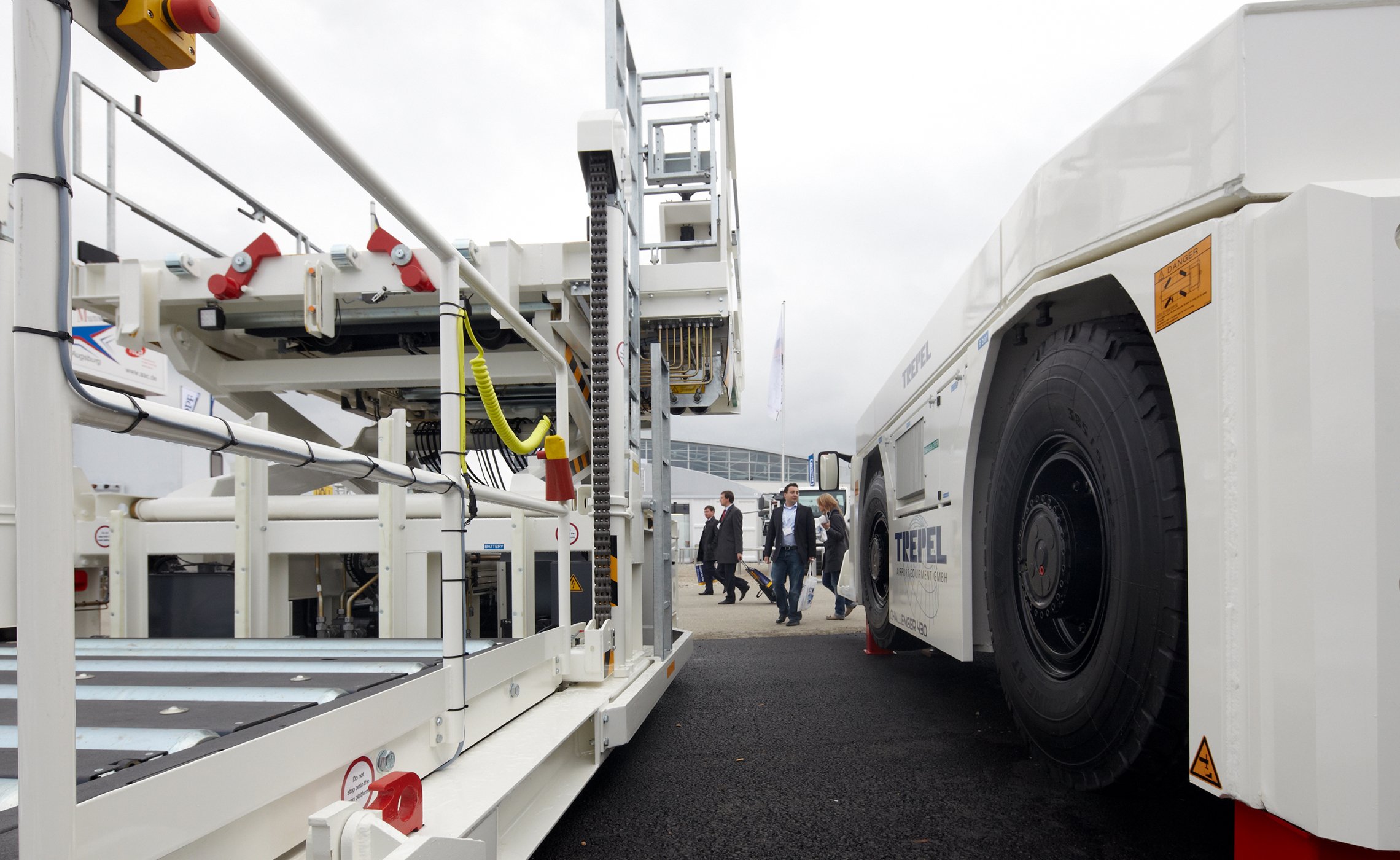Nahaufnahme eines TREPEL CHALLENGER-Schleppers neben einer Transport- und Hebeeinheit auf einer Messe