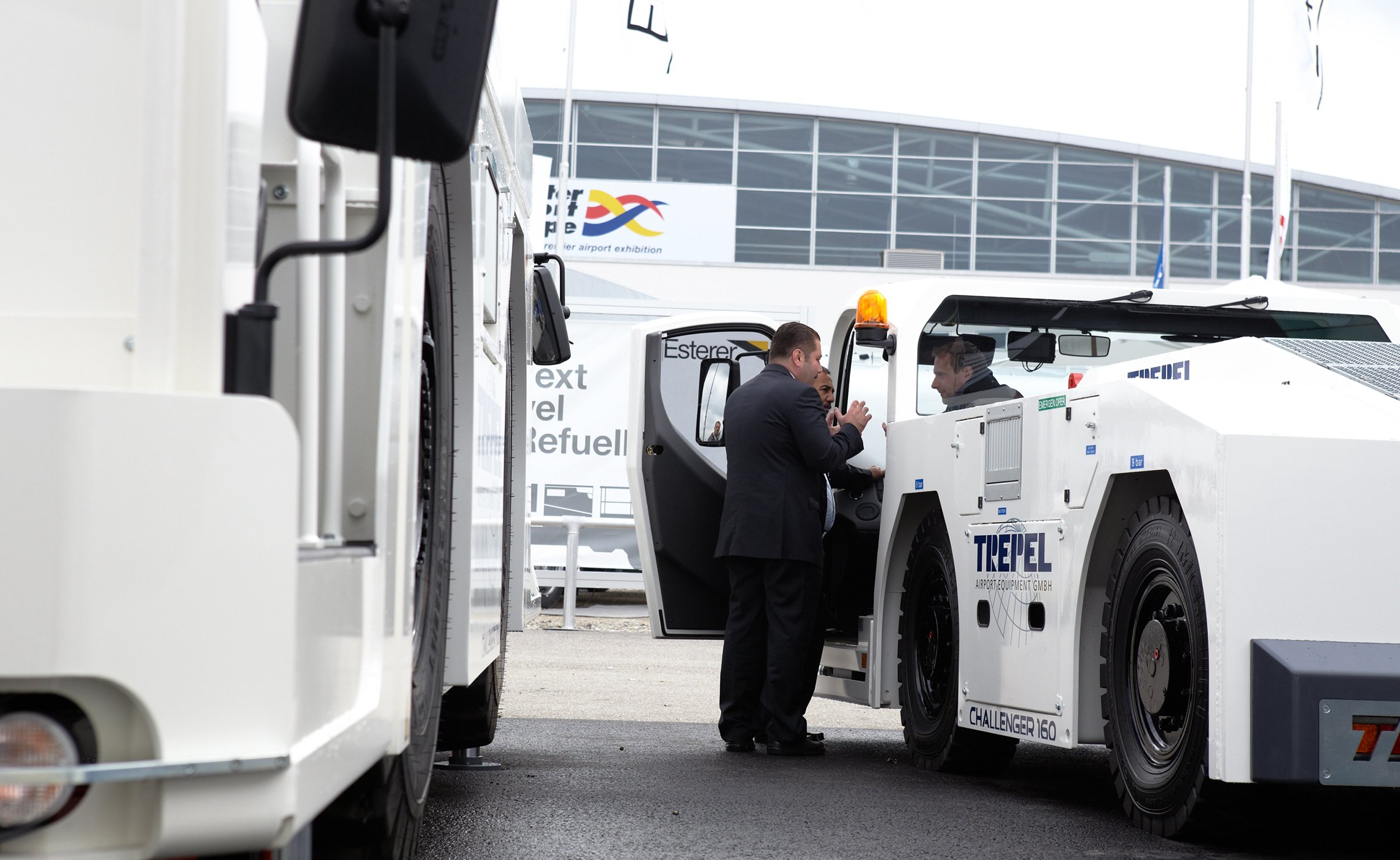 Zwei Männer stehen an der geöffneten Tür eines TREPEL CHALLENGER 160 und sprechen mit einem Fahrer in der Kabine