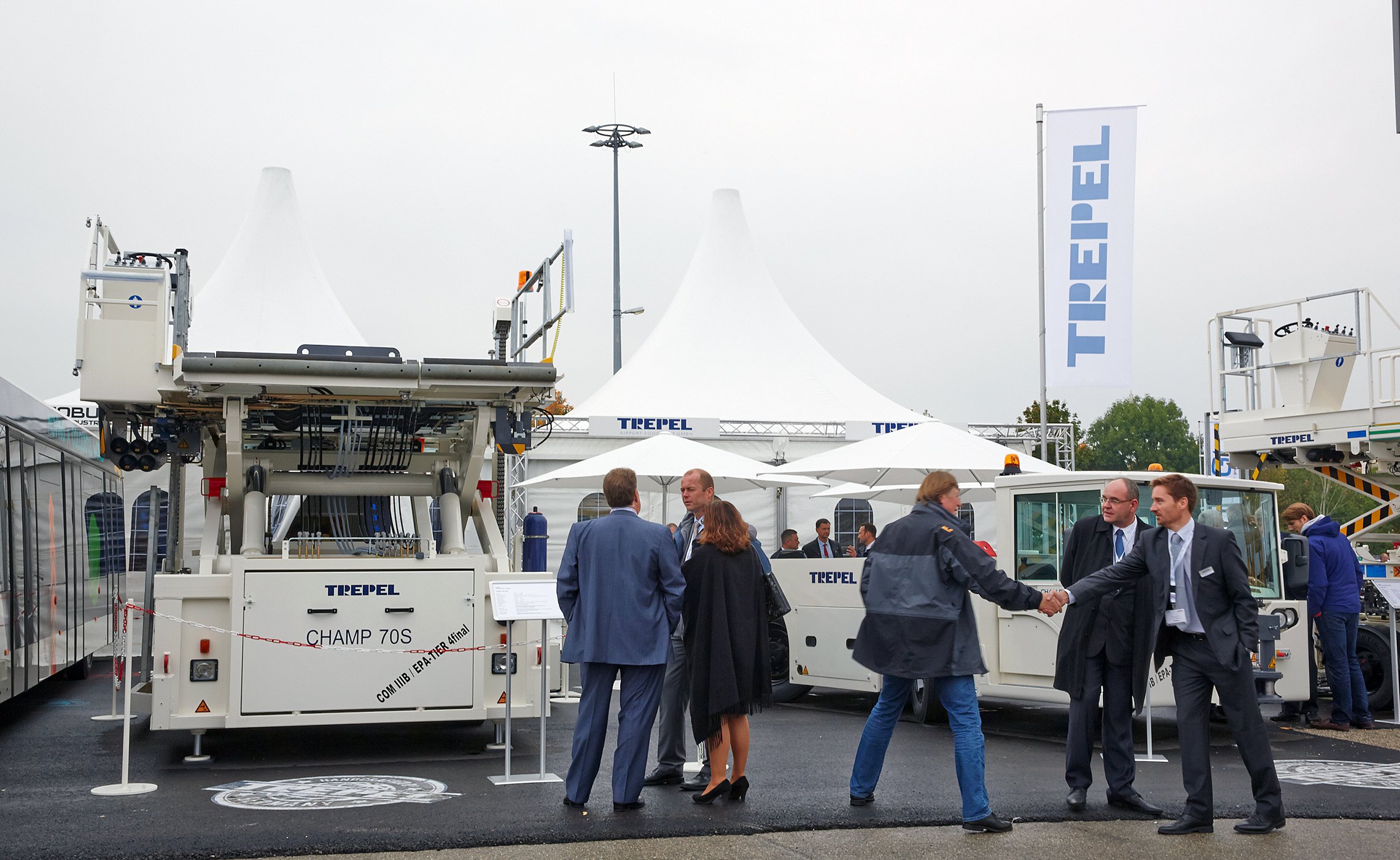 Besucher vor CHAMP 70S High Loader und Schleppern von TREPEL auf dem Messegelände
