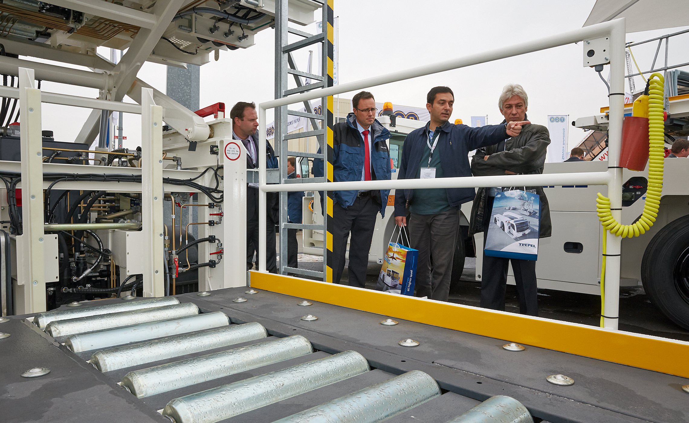 Gruppe von Fachbesuchern begutachtet die Technik eines TREPEL High Loaders auf der Messe