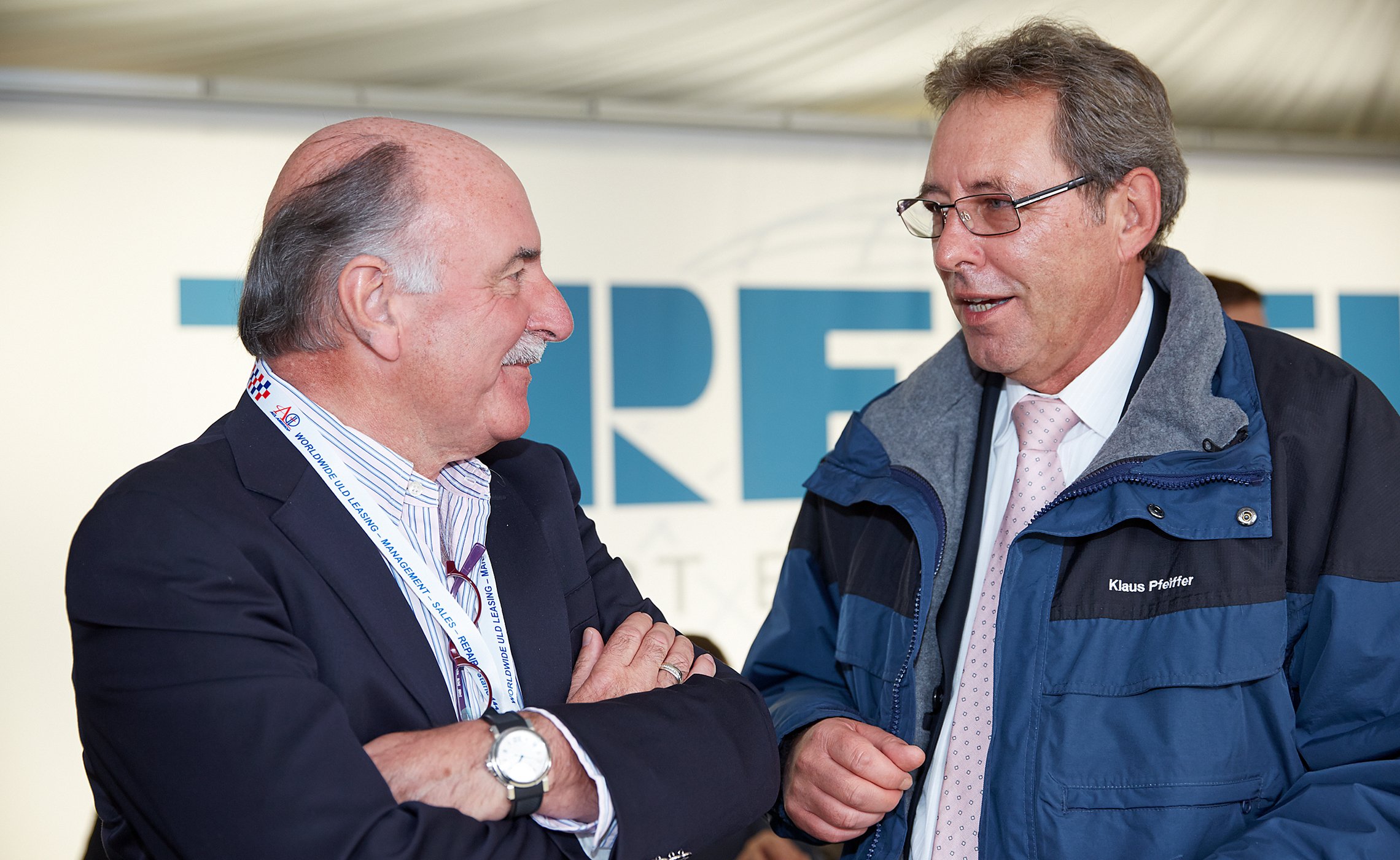 Zwei Männer im Gespräch, einer trägt eine Jacke mit dem Namen „Klaus Pfeiffer“, beide stehen vor einem TREPEL-Schriftzug