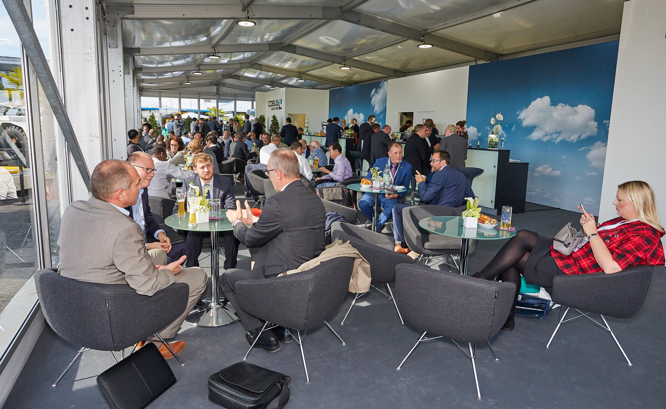 Visitors seated in the TREPEL indoor hospitality lounge with drinks and conversations