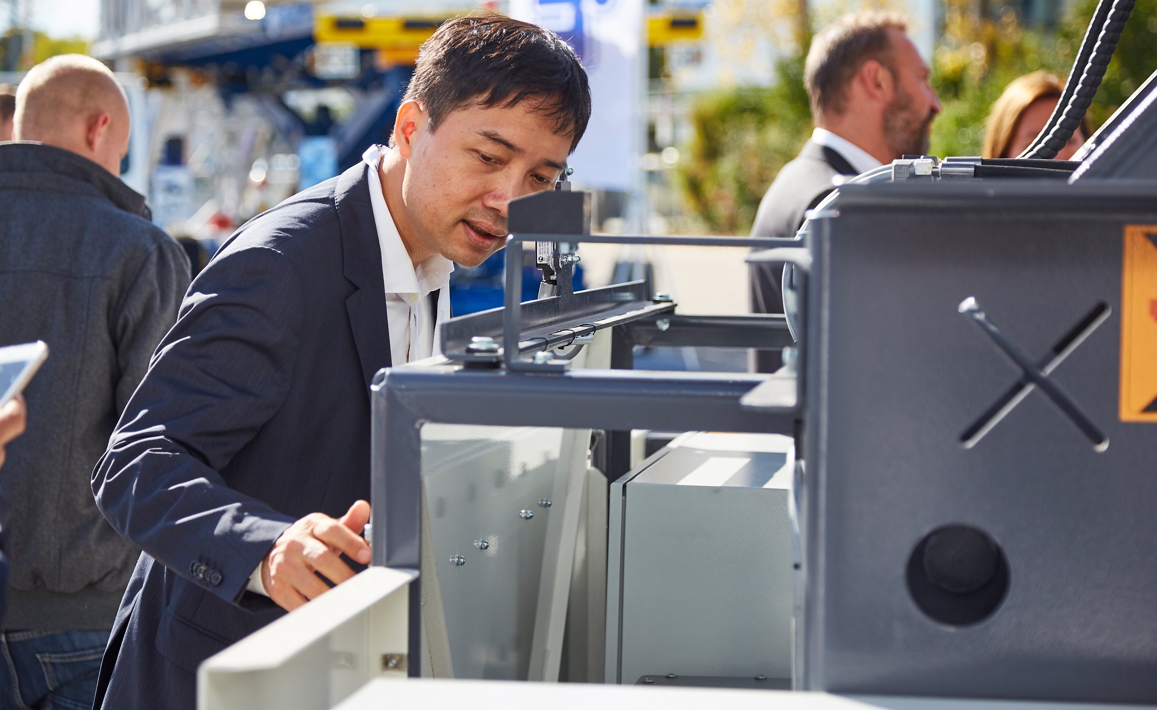 Man inspecting a TREPEL cargo loader component outdoors during a technical demonstration