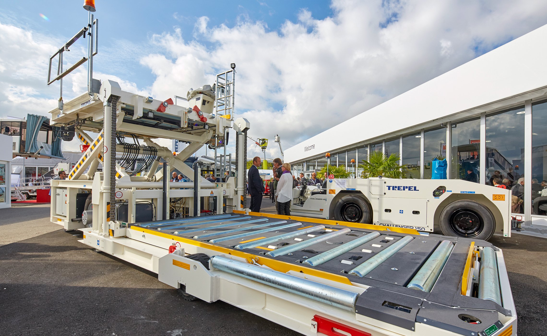 Zwei TREPEL GSE-Fahrzeuge, ein Highloader und ein Flugzeugschlepper, stehen vor dem Messepavillon