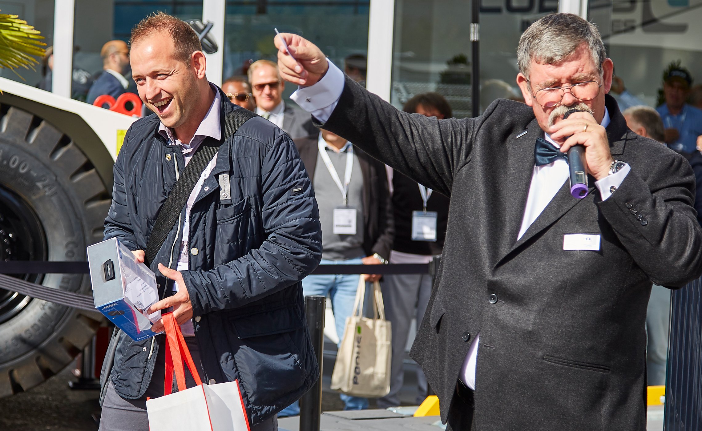 Mann erhält einen Preis, während Moderator den Gewinner verkündet