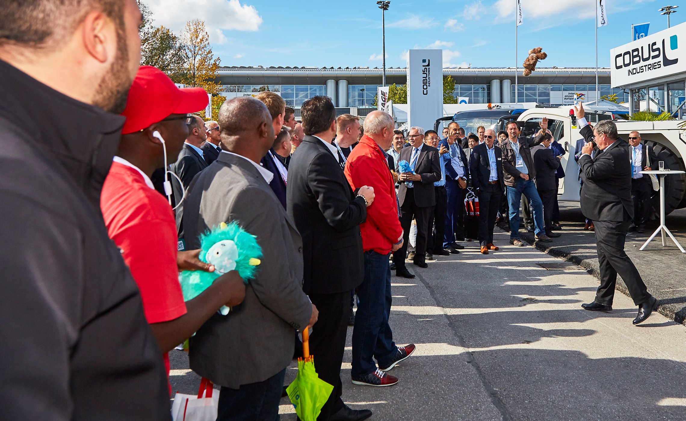Moderator wirft ein Stofftier in eine Menschenmenge bei einer Messeaktion